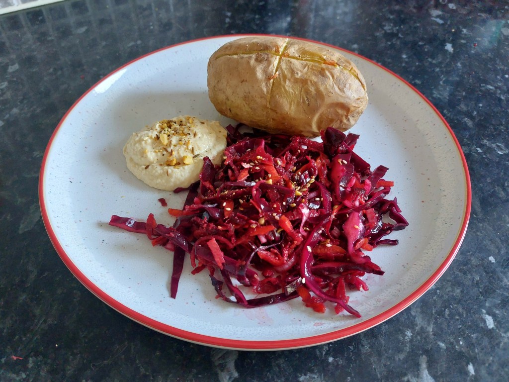 Photo of plate with hummus, beetroot slaw and a baked potato.